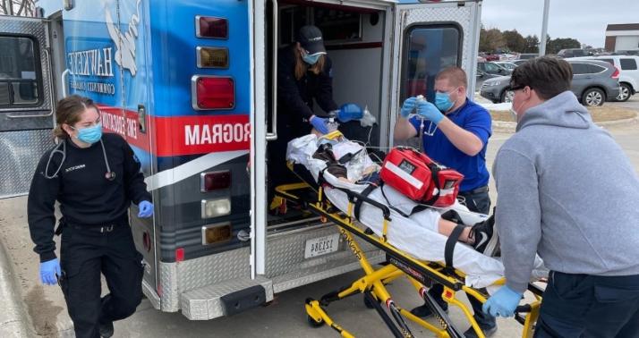 急救医学专业的学生练习把病人装上救护车